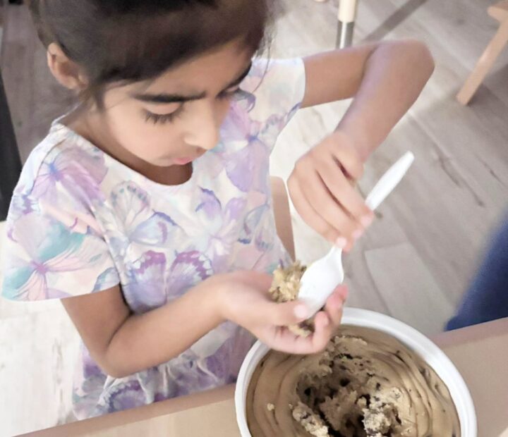 Child participating in a supervised cookie-baking activity
